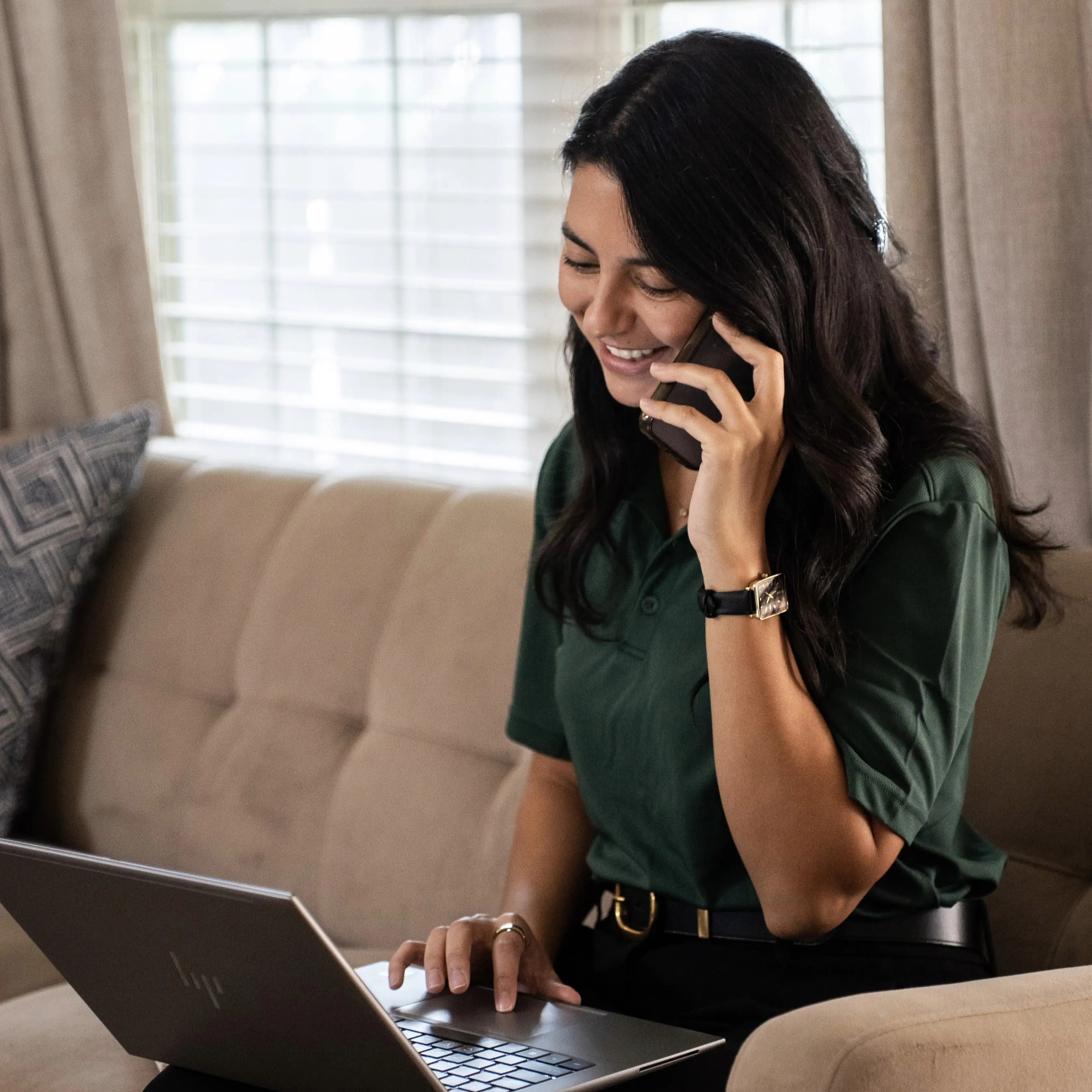 Karen on the phone with a client while working on her laptop